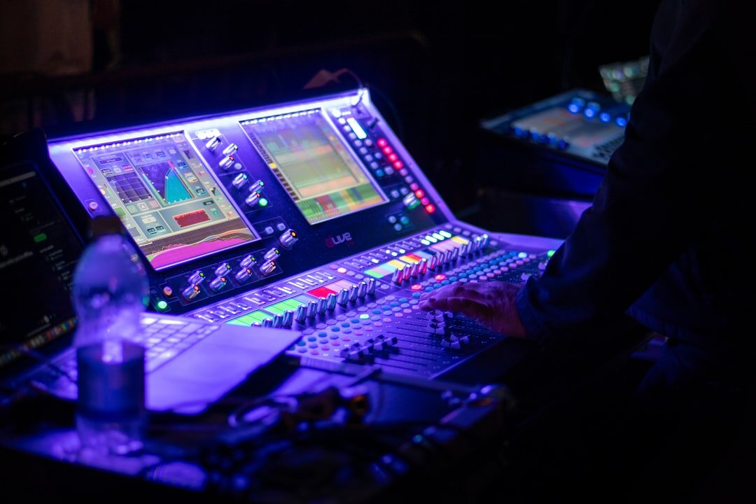 Broadcast engineer working at a technical desk with monitors and mixing equipment